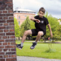 Kind springt von einer Mauer weg