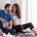 Ein Mann und seine schwangere Frau sitzen auf dem Boden.