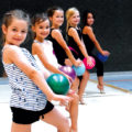 Eine Gruppe Mädchen mit ihren Bällen in einer Sporthalle