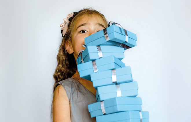 Mädchen mit einem Turm voller Geschenke