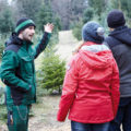 Mitarbeiter von Zingaschusters Christbaumkultur zeigt Kunden die Tannenbäume