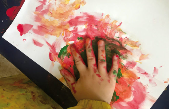 Farbverschmierende Kinderhand