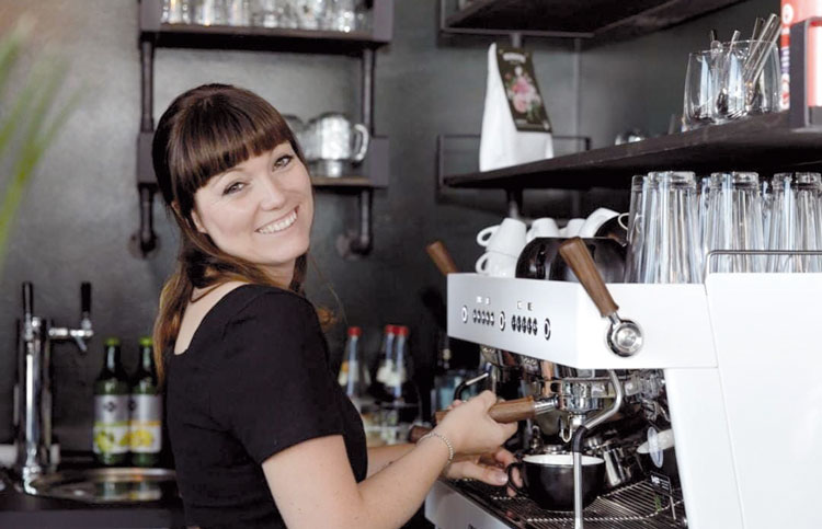 Eine Frau an einer Kaffee-Maschine