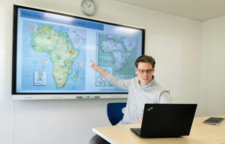 Lehrer zeigt auf einen Bildschirm mit einer angezeigten Karte von Afrika