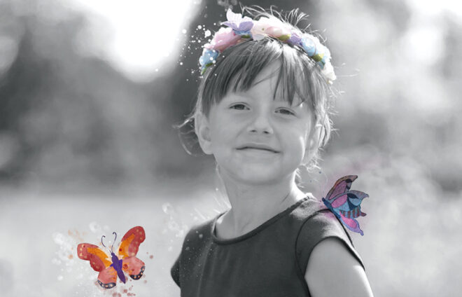 Monochromes Foto eines Mädchens mit bunten Schmetterlingen