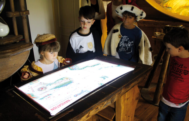 Kinder schauen sich im Museum eine Schatzkarte an