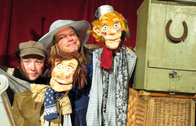 Schauspieler mit ihren Puppen spielen die Abenteuer des Tom Sawyer