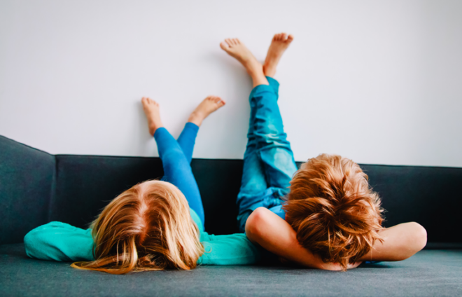 Kinder liegen auf dem Sofa