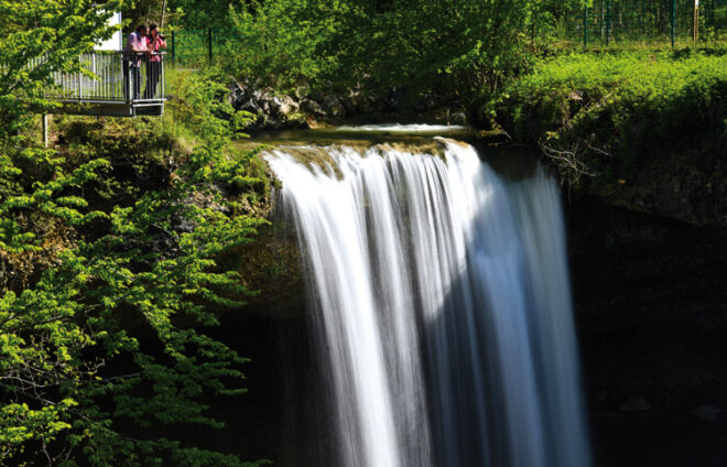 Menschen beobachten einen Wasserfall