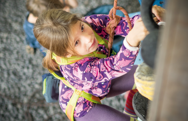 Kind klettert an der Wand