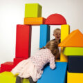Kinder spielen mit großen bunten Formen