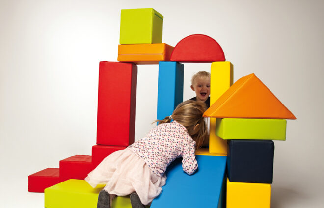 Kinder spielen mit großen bunten Formen