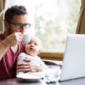 Vater mit Baby vor Laptop