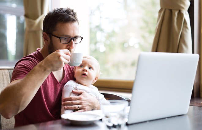 Vater mit Baby vor Laptop