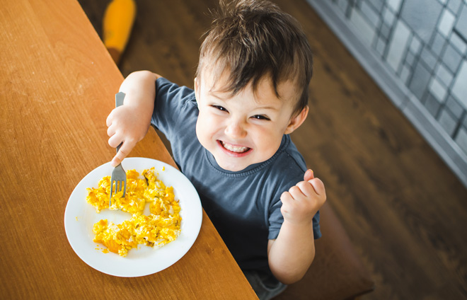 Kleinkind freut sich über Frühstück