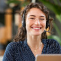 Frau mit Headset lächelt in die Kamera