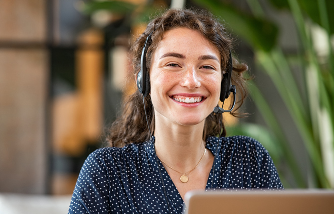 Frau mit Headset lächelt in die Kamera