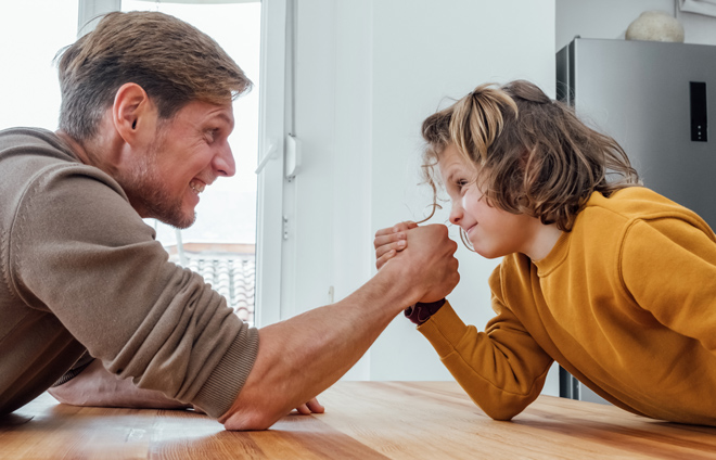 Vater und Kind beim Armdrücken