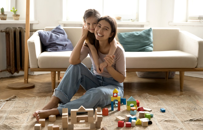 Mutter mit Kind und Bauklötzen im Wohnzimmer