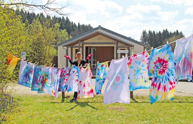 Frau mit Wäscheleine voller Batikstoffe