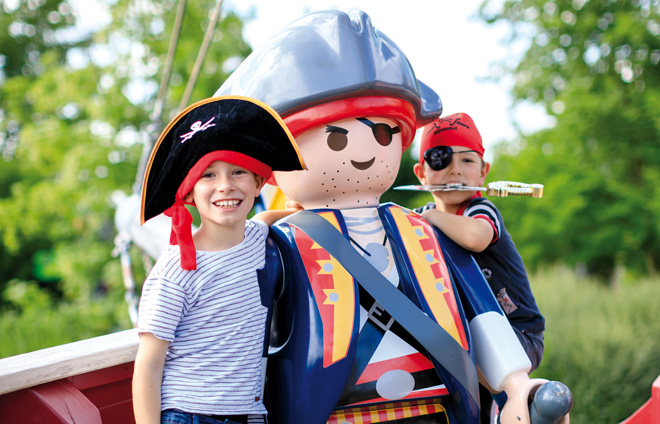 Kinder als Piraten bei einer übergroßen Playmobil-Figur