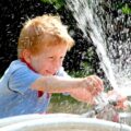 Kind spritzt mit Wasser
